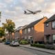 buitenaanzicht van een woonwijk onder een vliegroute